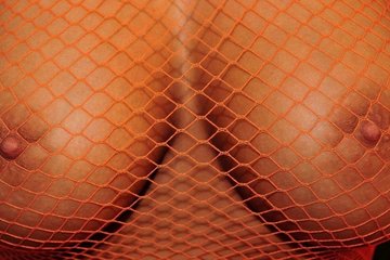 Сетчатый пеньюар полостью прозрачный. Он не скрывает ни полные натуральные сиськи, ни оранжевые стринги. Симпатичная брюнетка возбуждающе позирует и в конце концов снимает нижнее белье. Теперь она полностью обнажена, если опять таки, не считать сетчатого пеньюара.